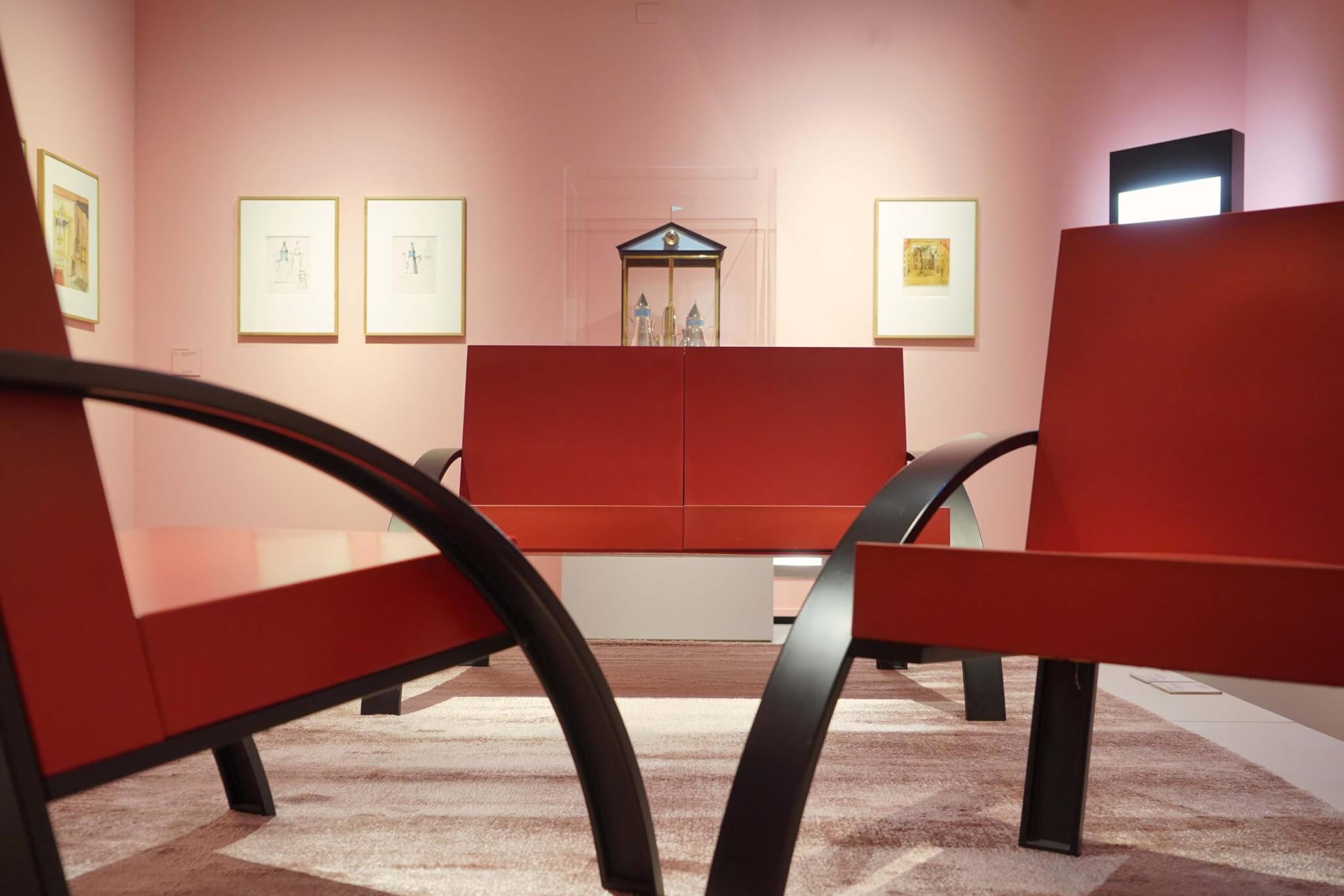 粉红色的展览空间里有红色的椅子