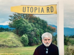 迈克·戴维斯的照片站在一个写着乌托邦路的牌子下