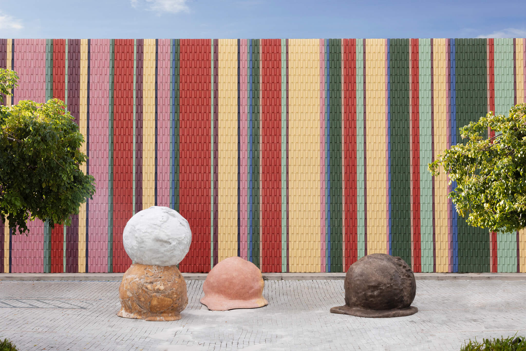 colorful mural wall with melting sculptures out front